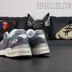 Kith x New Balance 991v2 ‘Osaka Pack’ angled heel shot showcasing layered panels and embroidered logos