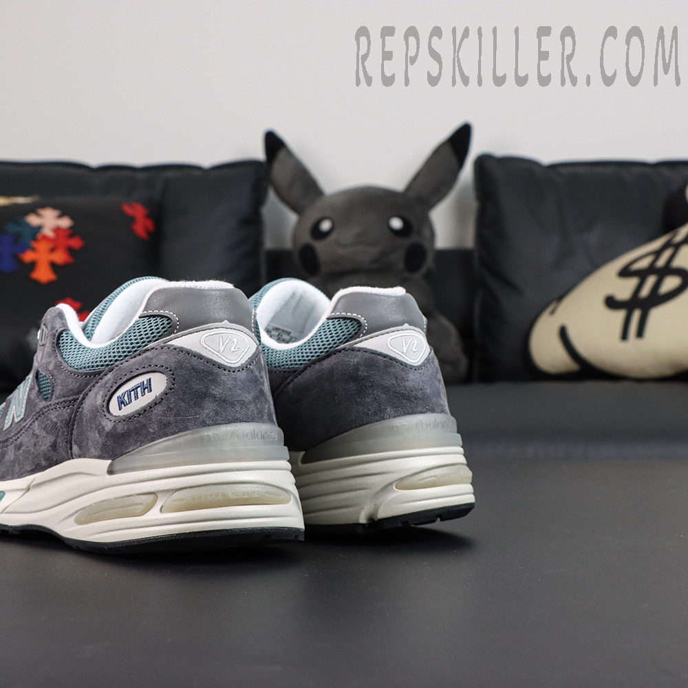 Kith x New Balance 991v2 ‘Osaka Pack’ angled heel shot showcasing layered panels and embroidered logos