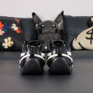 Rosé x Wmns Speedcat Premium ‘Black’ rear heel view showing rounded driver’s heel and off-white secondary lacing around the heel counter.