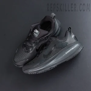 Nike Vomero 18 ‘Triple Black’ top-down layout revealing monochrome tongue, laces, and sleek silhouette