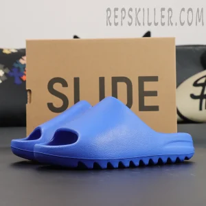 Yeezy Slides ‘Azure’ side view in front of original box with SLIDE text