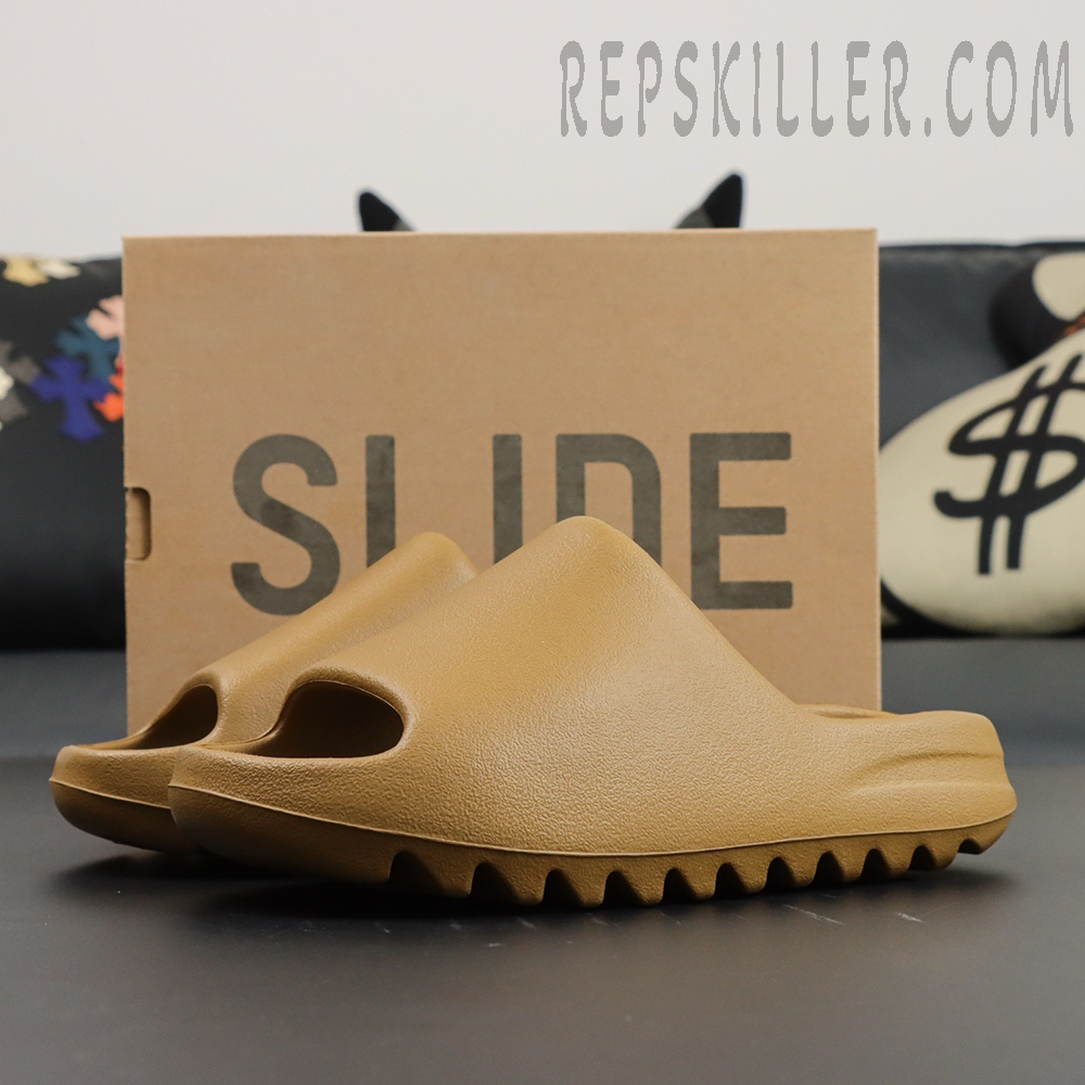 Pair of Yeezy Slides ‘Ochre’ side angle view in front of Slide box