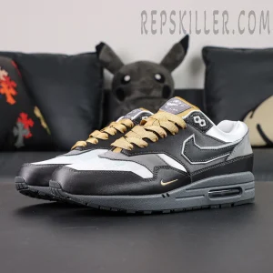 Three-quarter angle of Nike Air Max 1 “Low Poly - Big Head Mode” highlighting grey-white color blocking and reversed Swoosh logo.