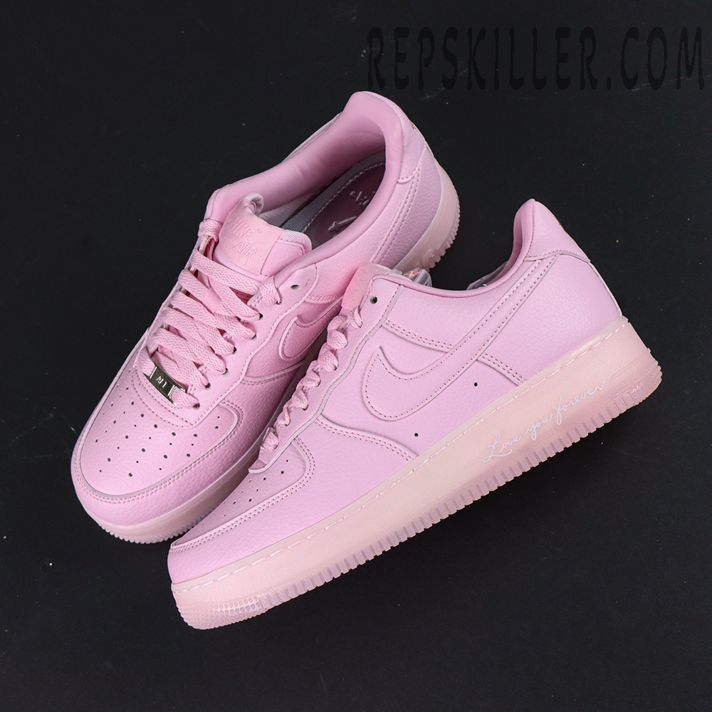 Overhead pair of NOCTA x Nike Air Force 1 “Pink Foam” showing full pink color and “Love You Forever” text on midsole.