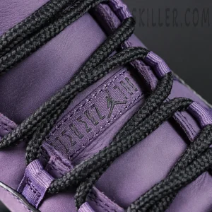 Close-up of the lace loop branding and black rope laces on the Jordan 11 Retro ‘Mojave’.